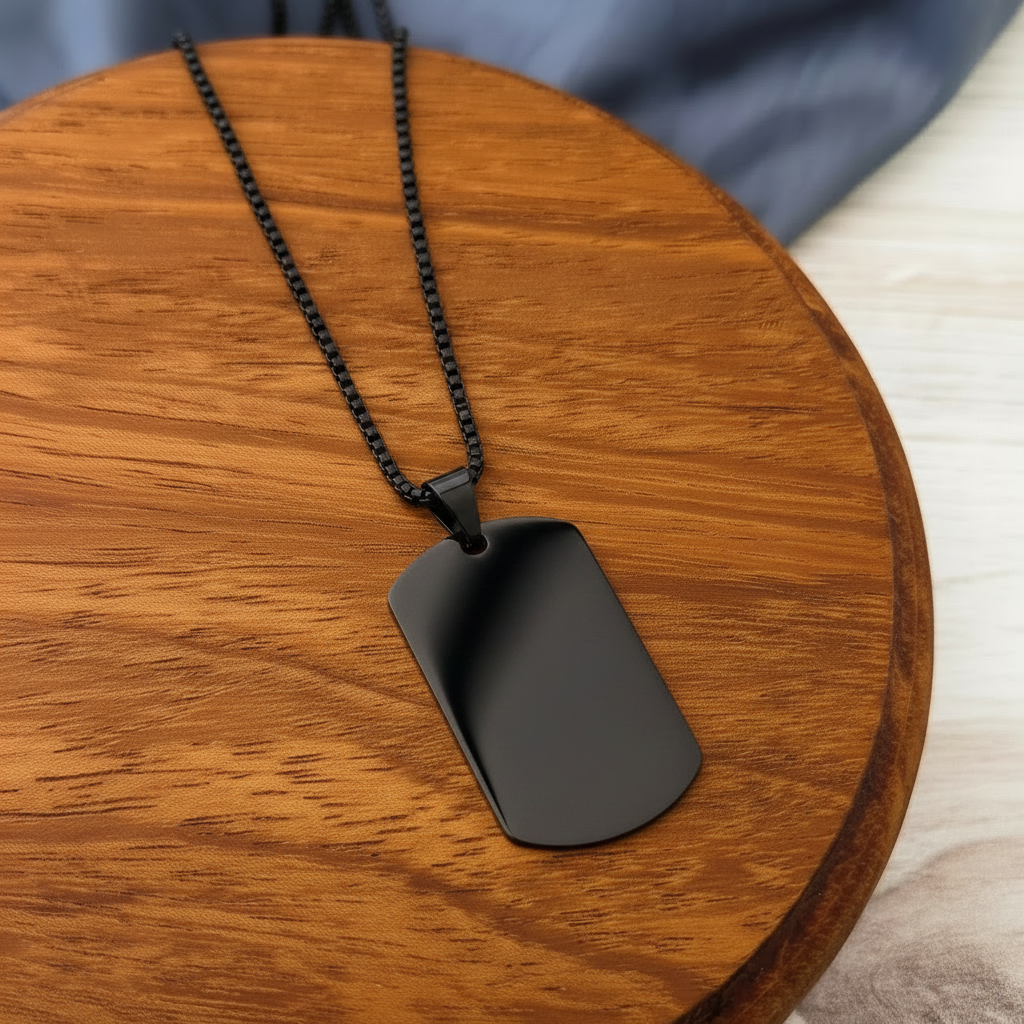 Roco Engraving black stainless steel dog tag necklace with a smooth mirror finish on a round wooden display base