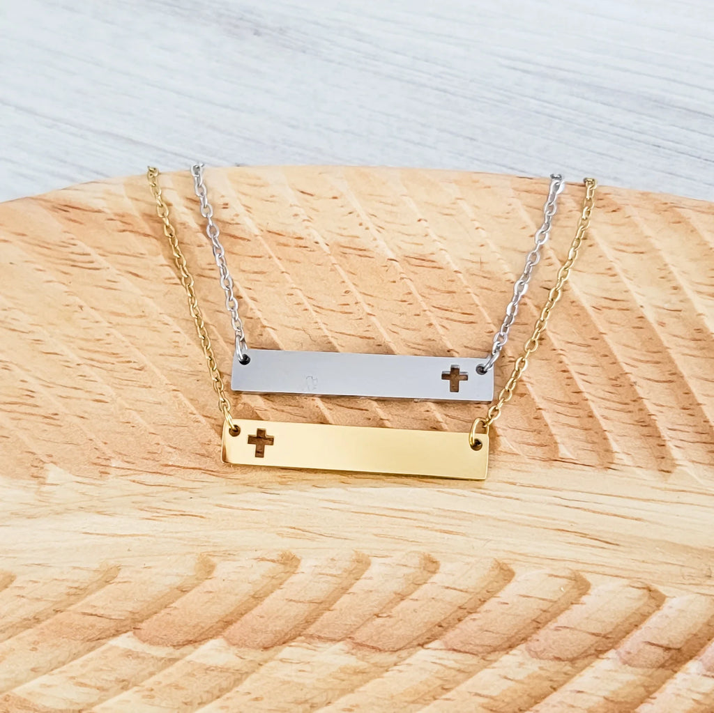Roco Engraving silver and gold stainless steel bar necklaces with cross cutouts on a wooden display