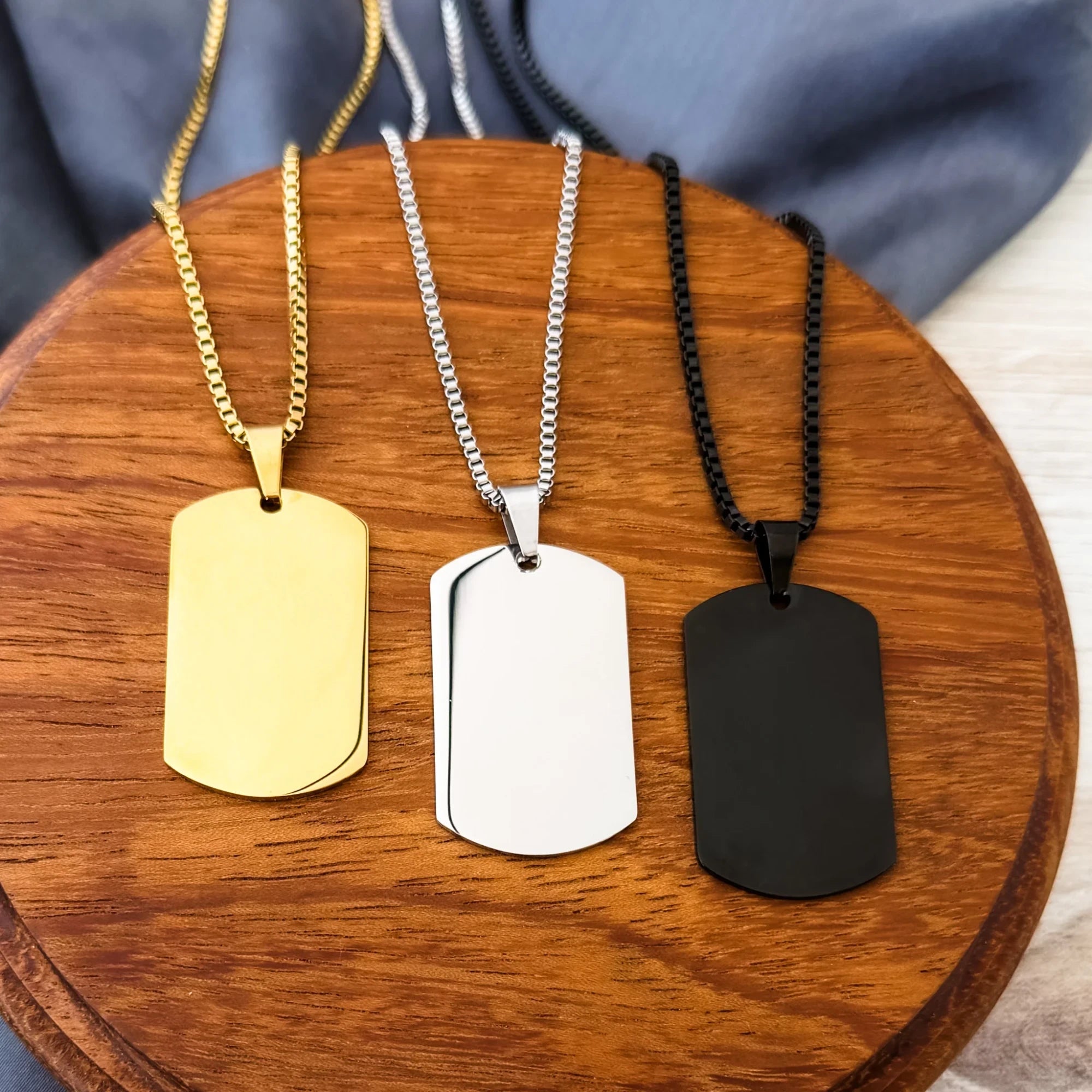 Roco Engraving custom dog tag necklaces in gold, silver, and black stainless steel with matching 18-inch chains.