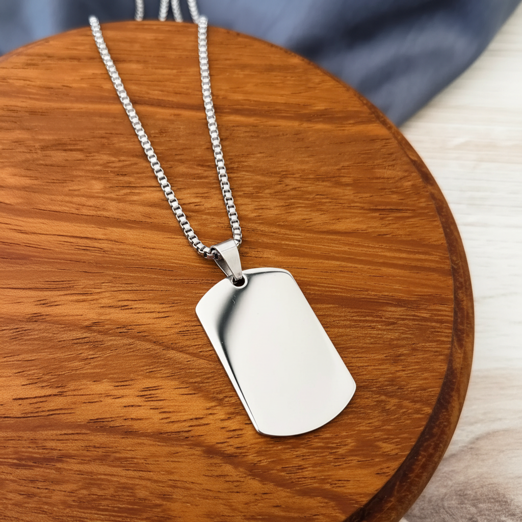 Roco Engraving silver stainless steel dog tag necklace with a smooth mirror finish on a wooden display base