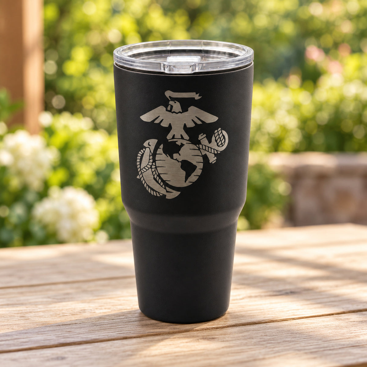 Black 30oz MakerFlo tumbler engraved with the Marines Emblem design, outdoors